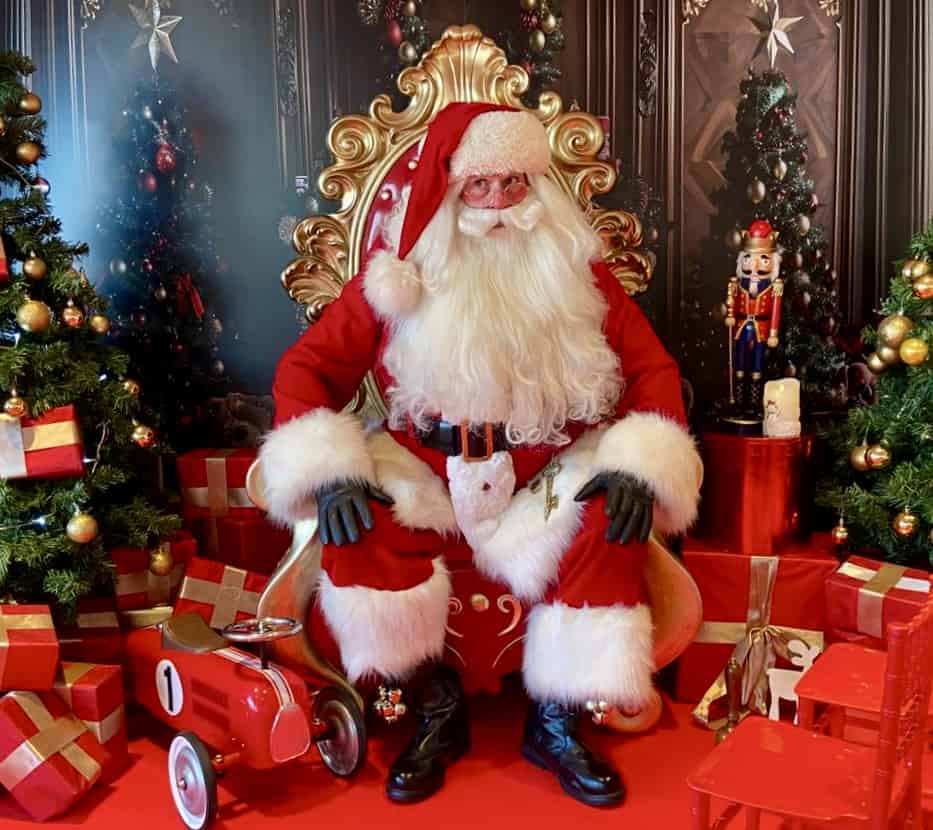 Santa sitting on a throne at a grotto.